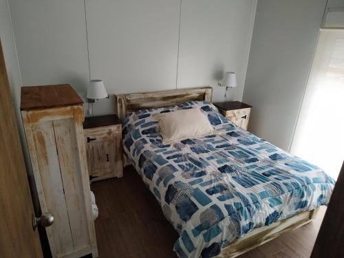 a bedroom with a bed with a blue and white comforter at Casita de Piedra 4 in Trinidad