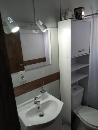 a bathroom with a sink and a toilet and a mirror at Casita de Piedra 4 in Trinidad