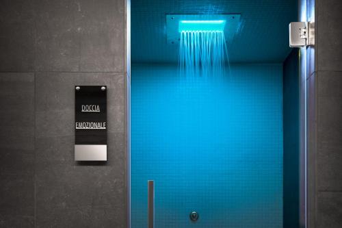 a bathroom with a blue door with a sign at LHP Hotel Montecatini Palace & SPA in Montecatini Terme