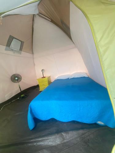 a tent with a blue bed in a room at Dunas Tatacoa in Villavieja