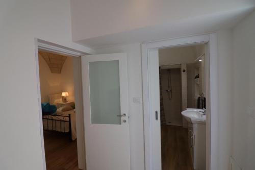een witte badkamer met een wastafel en een spiegel bij Casa Vacanza Glenda Otranto in Otranto
