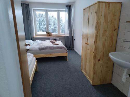 a bedroom with a bed and a sink and a window at Chata - Dom Horskej služby Jasna in Demanovska Dolina
