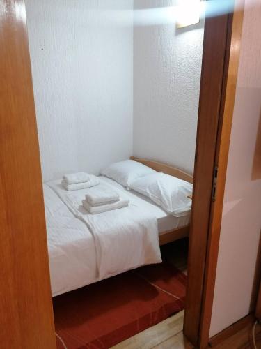 a small room with a bed with two towels on it at Guest House Villa Rankovic in Brzeće