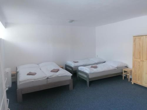 a room with three beds and a cabinet at Chata - Dom Horskej služby Jasna in Demanovska Dolina
