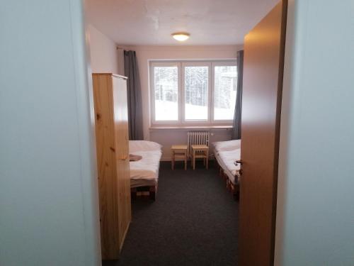 a room with two beds and a window at Chata - Dom Horskej služby Jasna in Demanovska Dolina