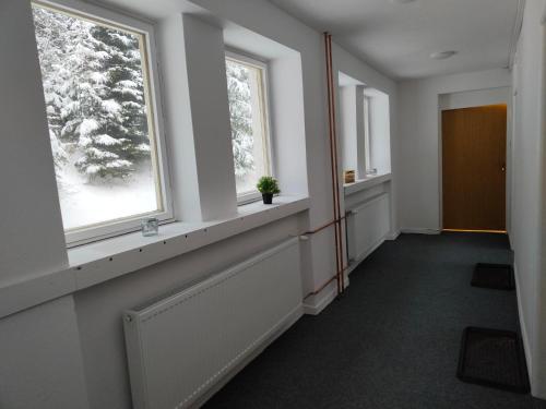 a hallway with two windows and a radiator at Chata - Dom Horskej služby Jasna in Demanovska Dolina