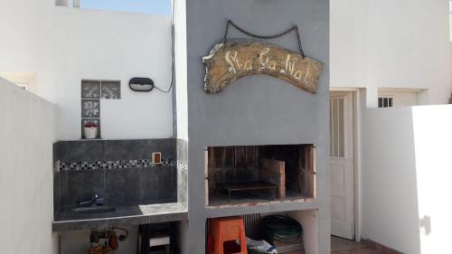 a living room with a fireplace and a sign on the wall at Maganal in Villa Carlos Paz