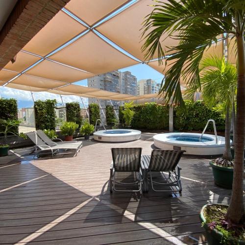 a patio with two chairs and two swimming pools at Eurobuilding Express Maracay in Maracay