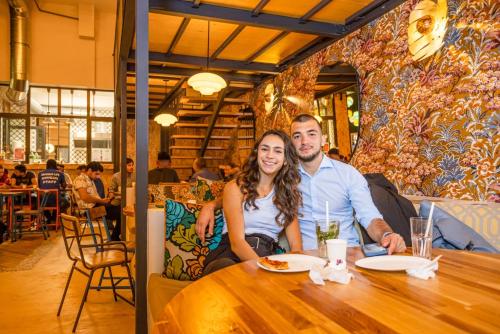 a man and woman sitting at a table in a restaurant at Villa Saint Exupery Beach Hostel in Nice
