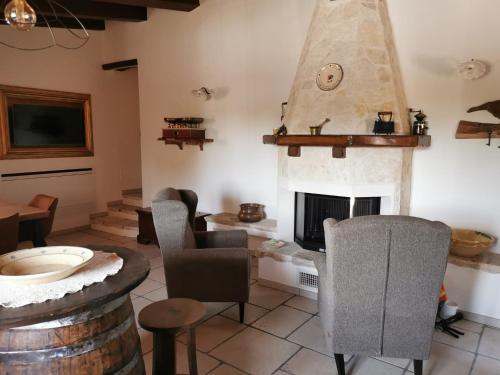 a living room with a fireplace and chairs at Villa "Il Trullo di Filomena" in Castellana Grotte