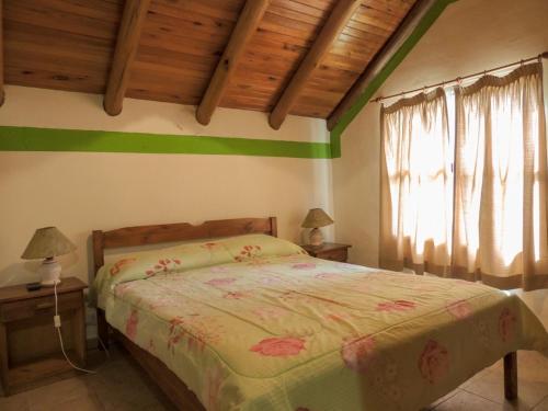 Dormitorio con cama con raya verde en la pared en Bungalows La Casona y Rincón Mágico en termas de Concordia en Concordia