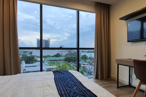 ein Zimmer mit einem großen Fenster mit einem Bett und einem Schreibtisch in der Unterkunft KOZI Square New SGH Cozy Home LV5A in Kuching