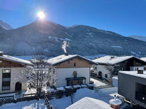 a snow covered village with a mountain in the background at Apartments Garden House in Niedernsill