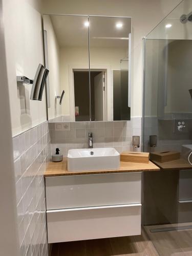 een badkamer met een witte wastafel en een spiegel bij Northastic Suite in Oostende