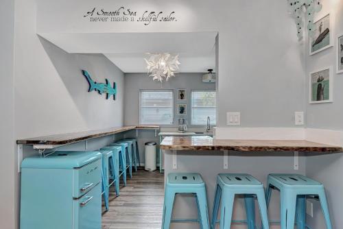a kitchen with blue stools at a counter at Mermaid-Shark 6BR House With Pool, Jacuzzi - Steps to Siesta Key Beach in Siesta Key