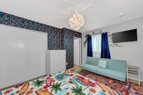 a living room with a blue couch and a tv at Mermaid-Shark 6BR House With Pool, Jacuzzi - Steps to Siesta Key Beach in Siesta Key