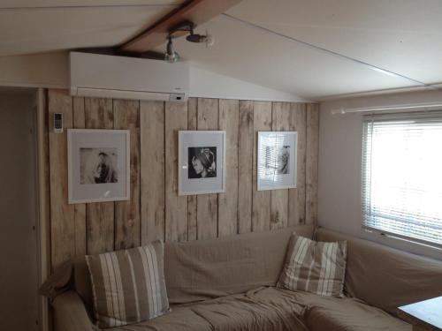 a living room with a couch and pictures on the wall at Mobilhome St Tropez 5H02 in Saint-Tropez