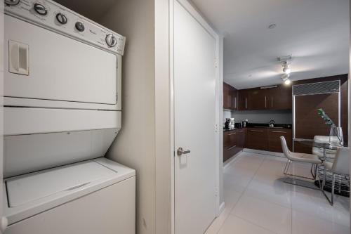 a kitchen with a white refrigerator and a dining room at Inredible View -Luxury Unit at the W Brickell in Miami