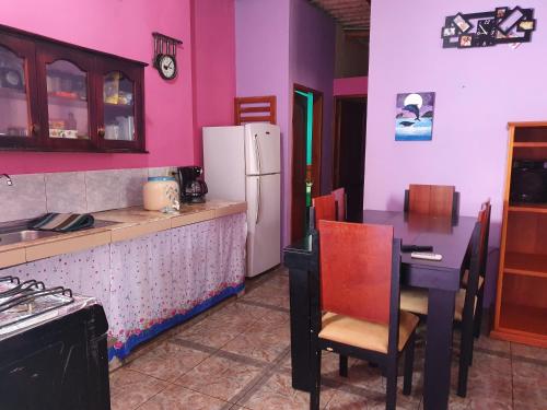 cocina con mesa y nevera blanca en Departamento Familiar en Santa Cruz, en Puerto Ayora