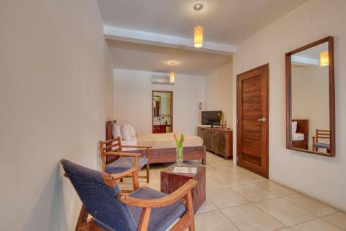 a living room with a bed and a table and chairs at Hotel Alcazar in San Juan del Sur