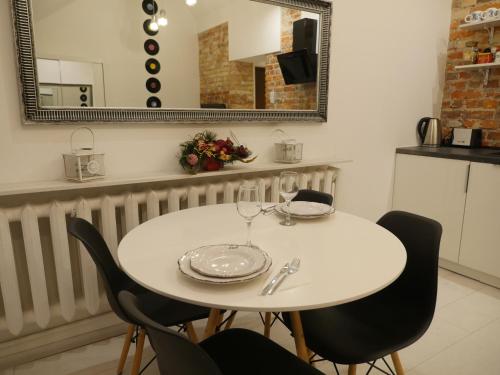 a white table with two chairs and a mirror at Art Vinyl Loft in Białystok