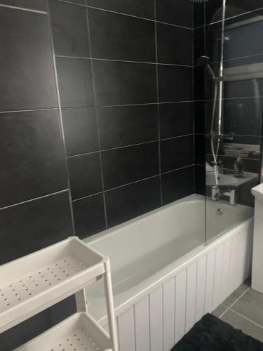 a bathroom with a bath tub and a sink at Stylish and Convenient in Belfast