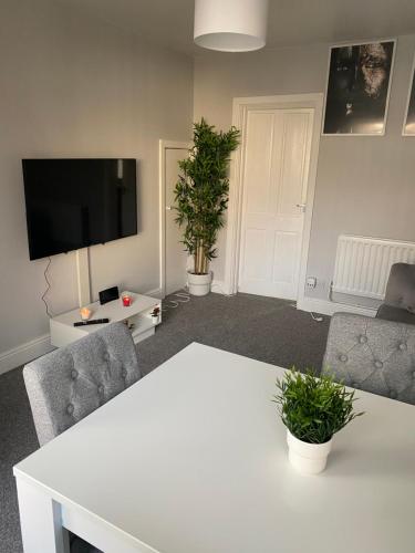 a living room with a white table and two chairs at Stylish and Convenient in Belfast