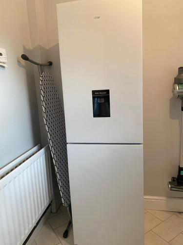 a white refrigerator with a microwave on top of it at Stylish and Convenient in Belfast
