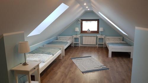 a attic room with three beds and a window at Apartamenty Tylicki Poranek in Tylicz