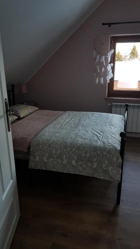 a bedroom with a bed and a window at Apartamenty Tylicki Poranek in Tylicz