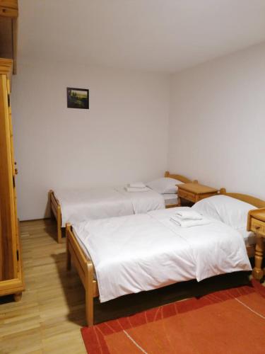 a group of three beds in a room at Guest House Villa Rankovic in Brzeće