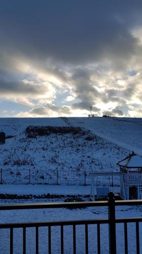 a snow covered field with a fence and a field at Apartamenty Tylicki Poranek in Tylicz