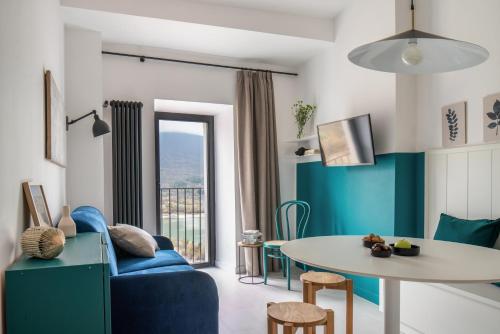 a living room with a blue couch and a table at La porticina. Your lake view home. in Barrea