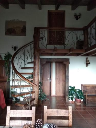 a spiral staircase in a room with two benches at Entre las Piedras y musgo in Muñopepe
