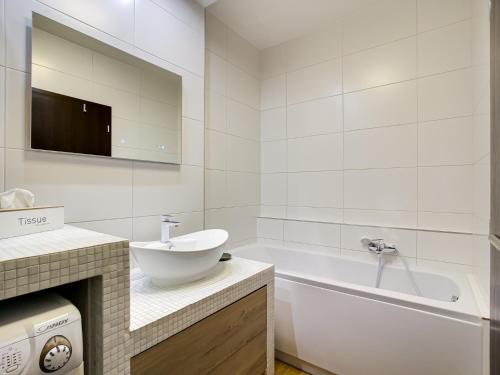 La salle de bains blanche est pourvue d'un lavabo et d'une baignoire. dans l'établissement Duna terrace, à Budapest