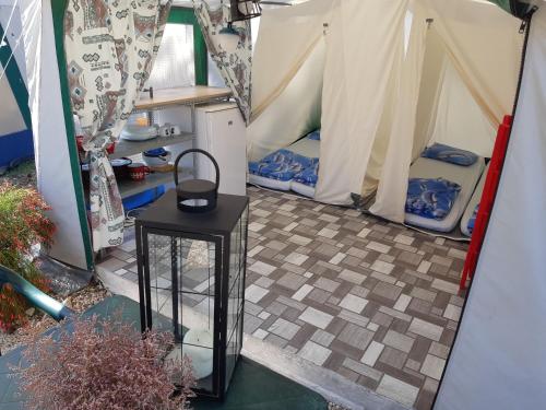 a small table in a tent with two beds at Camping Planik in Ražanac