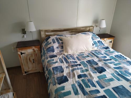 a bed with a blue and white quilt on it at Casita de Piedra 5 in Trinidad
