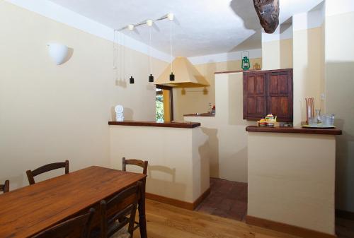 a kitchen with a wooden table and a dining room at Castello di Grillano Guest House in Ovada