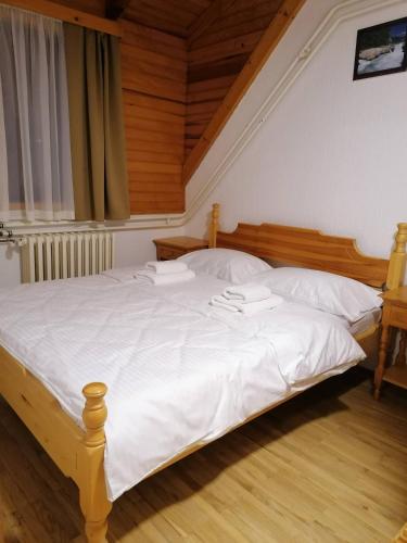 a bedroom with a large bed with white sheets at Guest House Villa Rankovic in Brzeće
