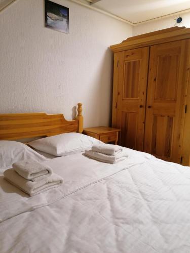 a bedroom with two white towels on a bed at Guest House Villa Rankovic in Brzeće