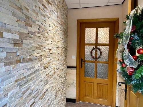 a door with a christmas wreath next to a brick wall at The Great View in Bouillon