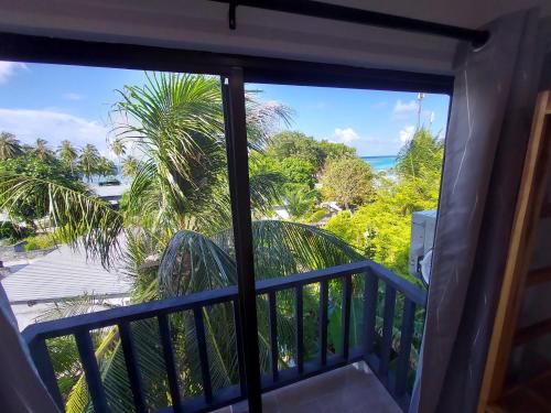 a room with a view of the ocean from a balcony at Palms Retreat in Fulhadhoo