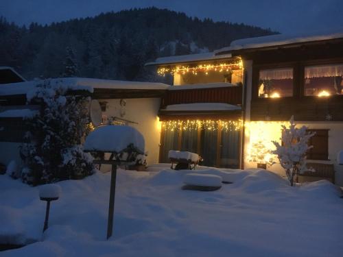 a house with christmas lights in the snow at Landhaus Renata Bayrischzell in Bayrischzell