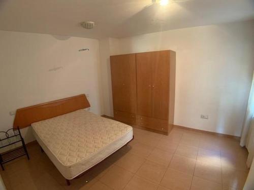a bedroom with a bed and a wooden cabinet at VUT SEGEDA Valle del Manubles in Calatayud