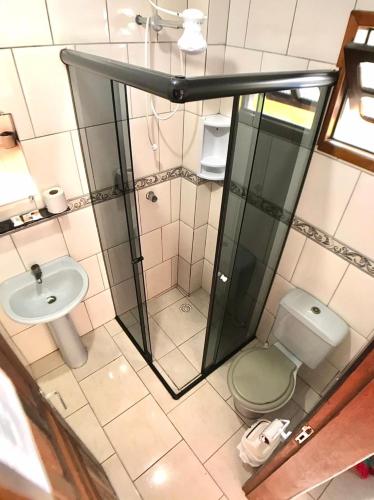 a bathroom with a shower and a toilet and a sink at Guaraflat in Guaratuba