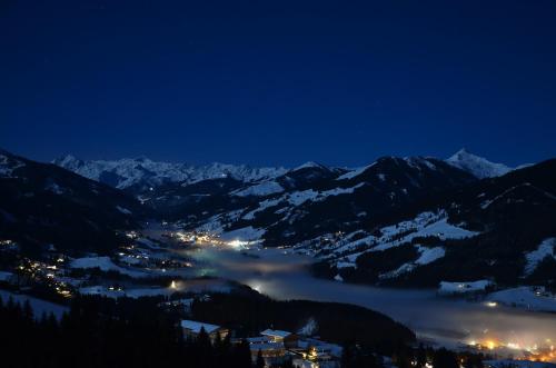 a view of a town in the mountains at night at Hof Hamoos in Kitzbühel