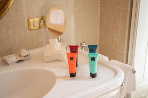 a bathroom with two cups on a sink at Villa Palmira Kinderfreies Hotel in Cannobio