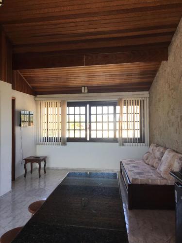 a large living room with a couch and windows at Guaraflat in Guaratuba