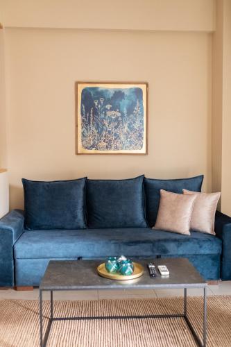 a blue couch in a living room with a table at Studio Dieci in Drama