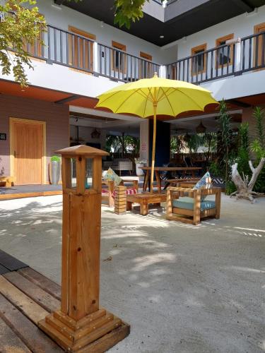 a yellow umbrella sitting in front of a building at Palms Retreat in Fulhadhoo